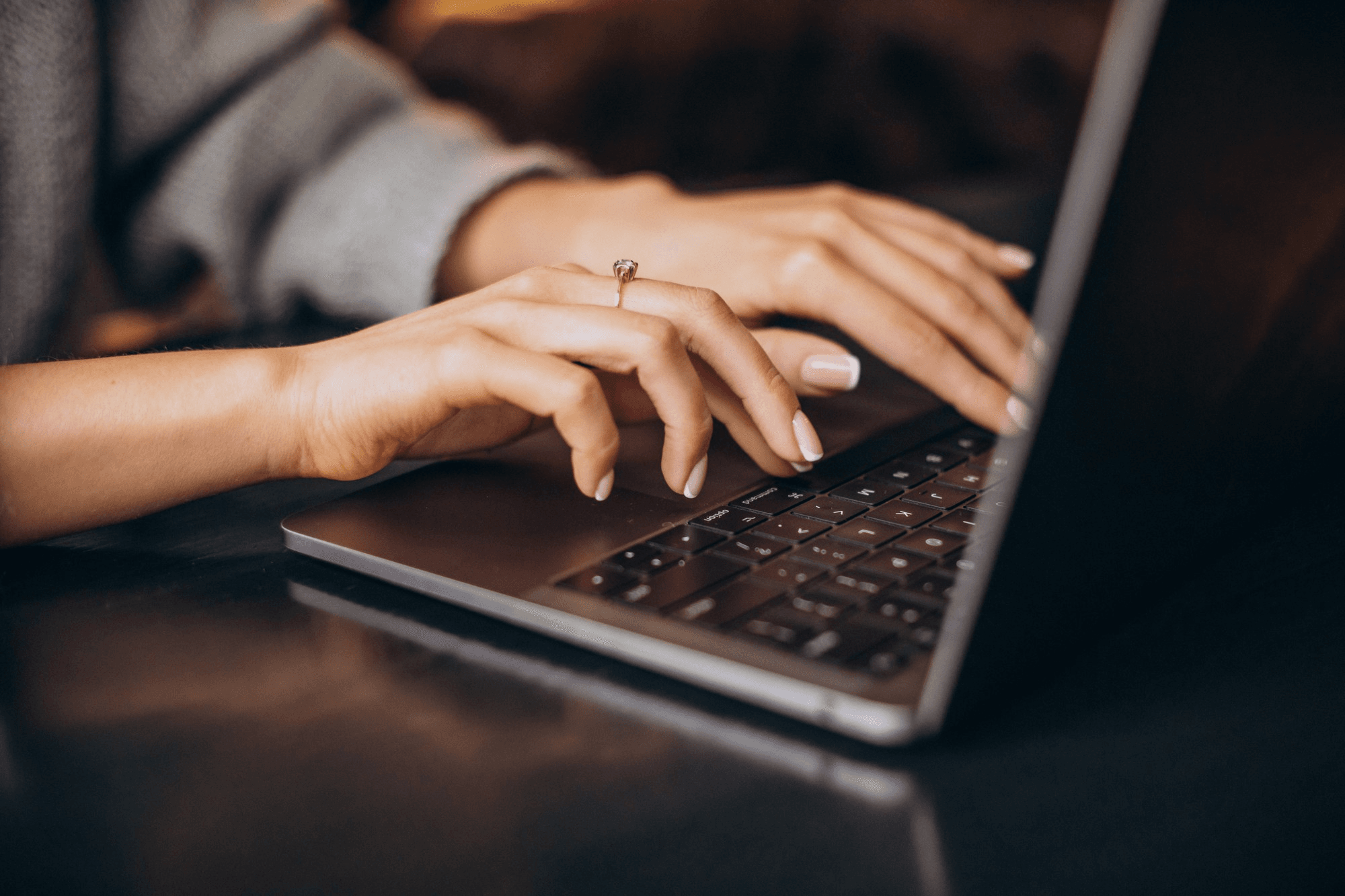 Hands working on a laptop.